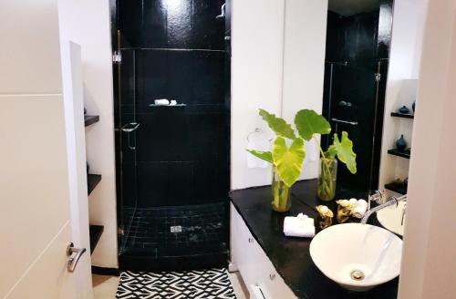 a bathroom with a black shower and a sink at Beach Apartment - Trou aux Biches - Ground Floor in Mont Choisy