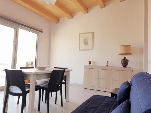 a living room with a table and chairs and a couch at A(m)mare - casa vacanze in Donnalucata