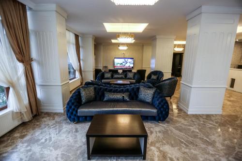 a lobby with couches and a television in a building at Thermal Saray Hotel & Yalova in Gokcedere