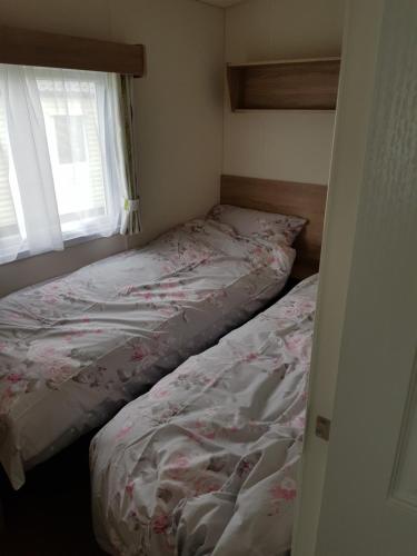 a bedroom with a bed and a window at Delta Santana in Looe