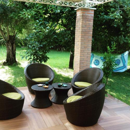 grupa wiklinowych krzeseł i stołów na patio w obiekcie Bed&Breakfast La Zagara w mieście Querceta