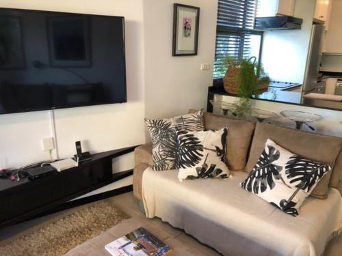 a living room with a couch with pillows on it at Beach Apartment - Trou aux Biches - Ground Floor in Mont Choisy