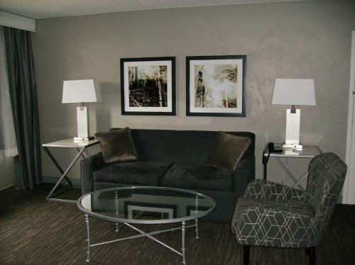a living room with a couch and a glass table at Best Western Plus Bradford Inn in Bradford