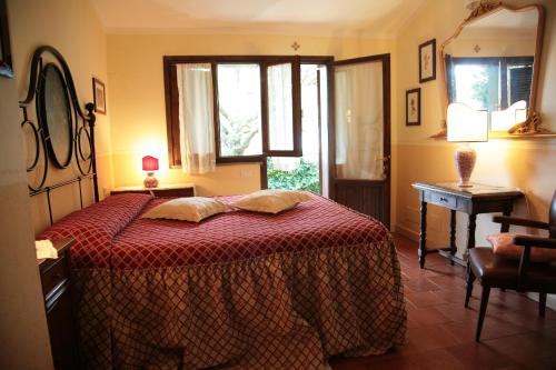 a bedroom with a bed and a table and a mirror at Malvarina in Capodacqua