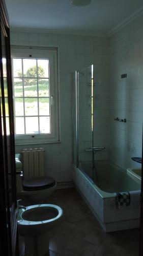 a bathroom with a tub and a toilet and a sink at Casa Braña in Barreiros