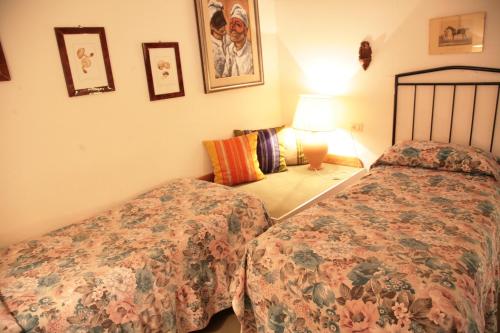 a bedroom with two beds and a lamp at Malvarina in Capodacqua