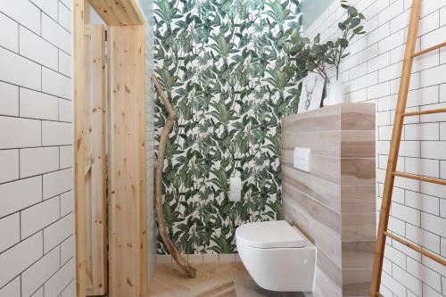 a bathroom with a toilet and a green and white wall at DOM NAD MORZEM PoDDĄBIE, TARAS WIDOKOWY ZE STREFĄ WYPOCZYNKU, SALA ZABAW in Poddąbie