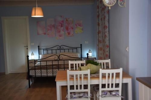 a bedroom with a bed and a table and chairs at Petite maison in Negrar