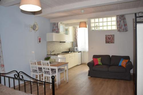 ein Wohnzimmer und eine Küche mit einem Sofa und einem Tisch in der Unterkunft Petite maison in Negrar