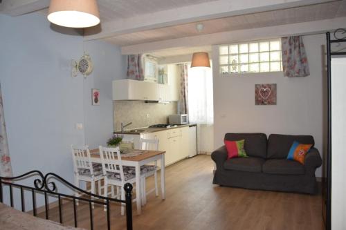 a living room and kitchen with a couch and a table at Petite maison in Negrar