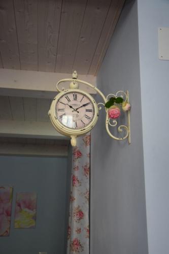 a gold clock hanging on a wall at Petite maison in Negrar