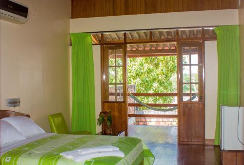 1 dormitorio con 1 cama y puerta corredera de cristal en Hotel Rio Huallaga en Yurimaguas