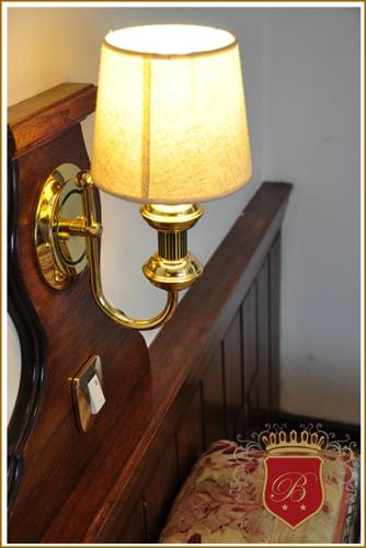 a lamp is attached to a wall next to a bed at Hotel Berlin in Gualeguaychú