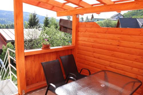 Un patio con una mesa y sillas y una ventana. en Domcek na orave, en Habovka