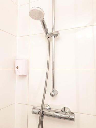 a shower with a shower head in a bathroom at Aparthotel Pan Haus in Bad Ischl