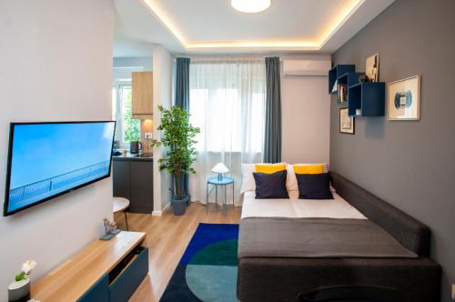 a living room with a bed and a flat screen tv at Victor Residence in Belgrade