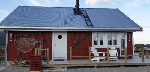 a red shed with a white door and a porch at Valberg High Quality Seaview Cabin in Valberg