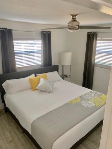 a bedroom with a large white bed with yellow pillows at Near Beaches & IMG Academy, Mins to Downtown in Bradenton