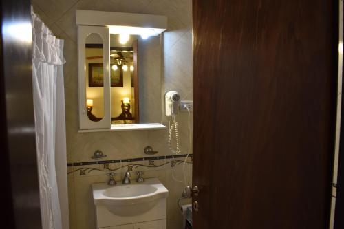 a bathroom with a sink and a mirror at Hotel Berlin in Gualeguaychú