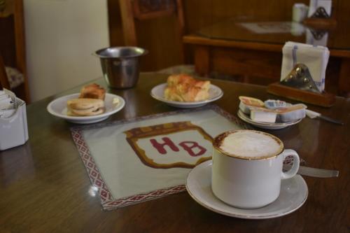 a table with a cup of coffee and pastries on it at Hotel Berlin in Gualeguaychú