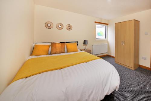 a bedroom with a large bed with orange pillows at No 10 LimeHouse in Oldham