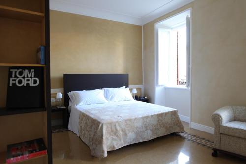 a bedroom with a bed and a chair and a window at Relais Del Borgo Hotel & Spa 4 Stelle in Staffolo