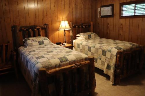 a bedroom with two beds and a lamp on a table at Lone Fir Resort in Cougar