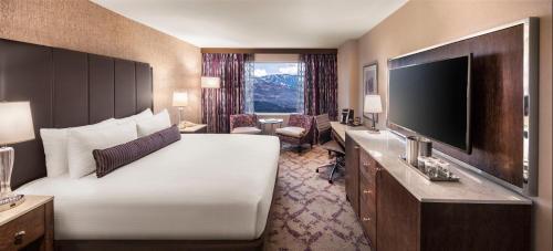 a hotel room with a large bed and a flat screen tv at Silver Legacy Reno, A Caesars Destination in Reno