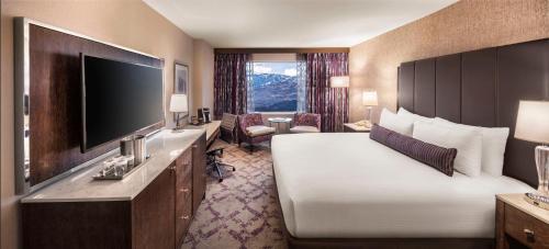 a hotel room with a bed and a flat screen tv at Silver Legacy Reno, A Caesars Destination in Reno