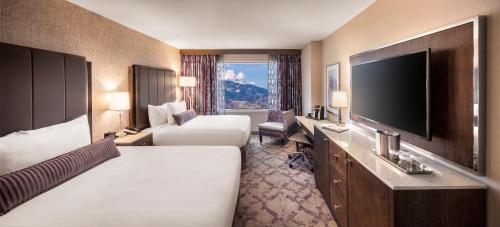 a hotel room with two beds and a flat screen tv at Silver Legacy Reno, A Caesars Destination in Reno