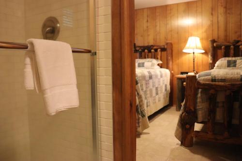 a bathroom with a shower and a bed in a room at Lone Fir Resort in Cougar