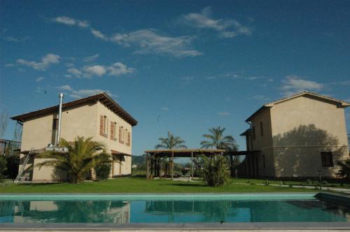 una casa e una piscina di fronte a una casa di Fattoria Il Giardo a Pietrasanta