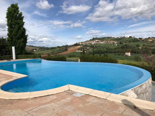 a large blue swimming pool with a mountain in the background at B&B Casa Fanny Riviera Del Conero in Loreto
