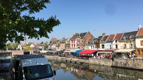 a car parked next to a river in a town at Le 3 fuscien in Amiens