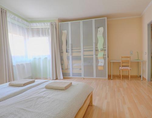 a bedroom with a bed and a desk and a window at H-Apartments in Trier