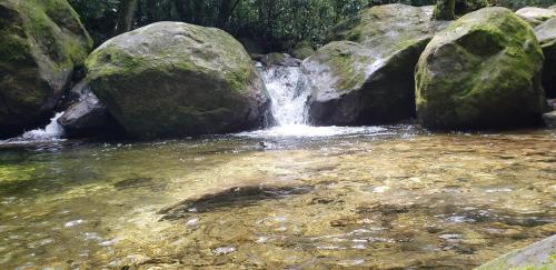 a small waterfall in a river with rocks at Casa Canto do Mar Maresias 2 in Maresias