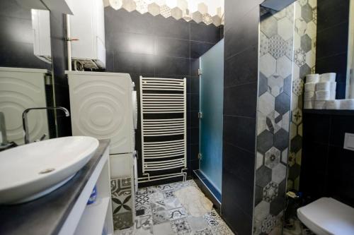W łazience znajduje się umywalka, toaleta i prysznic. w obiekcie East-West w Sarajewie