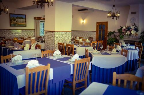 ein Restaurant mit blauen und weißen Tischen und Stühlen in der Unterkunft Hotel Beira Dão in São Gemil