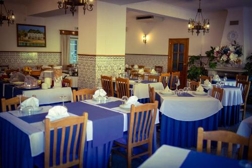 un restaurante con mesas y sillas azules y blancas en Hotel Beira Dão, en São Gemil