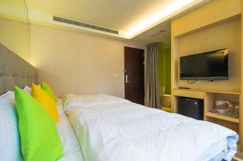 a hotel room with a bed with a flat screen tv at Crystal Inn Sun Moon Lake in Yuchi