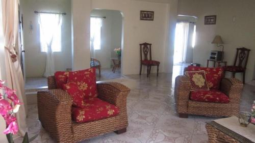 a living room with two chairs and red pillows at Prime Ocean View Vacation Villa in Plaisance