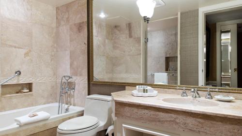a bathroom with a tub and a toilet and a sink at Wedgewood Hotel & Spa - Relais & Chateaux in Vancouver