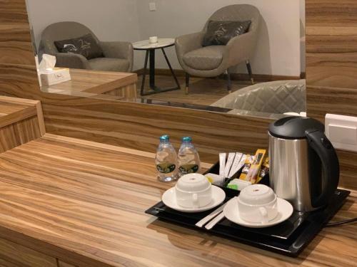 een tafel met een dienblad met een koffiezetapparaat en een spiegel bij ساس رتل للوحدات السكنية المفروشة in Al Madinah