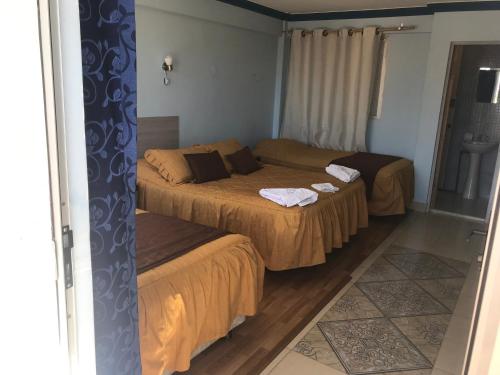 a bedroom with two beds and a window and a door at Le Ciel d'Uyuni in Uyuni