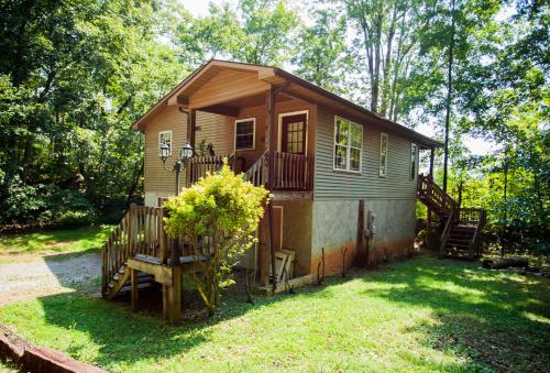 a small tiny house with a porch and a deck at Nolichuckey Bluffs Bed & Breakfast Cabins in Greeneville
