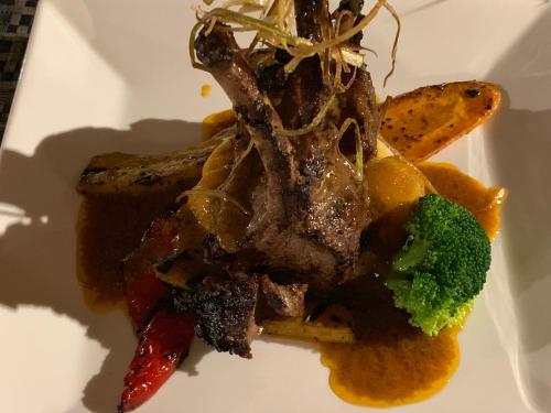 a plate of food with a piece of meat and broccoli at Yadua Bay Resort & Villas in Yandua