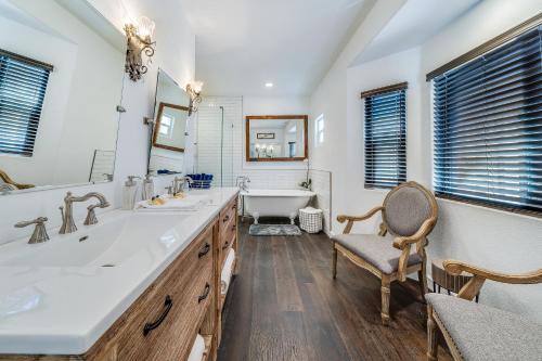 a bathroom with two sinks and a tub and a chair at 6 THE WHITE HOUSE in Huntington Beach