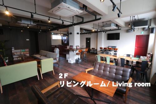 a large room with tables and chairs and a dining room at RED HELMET House & Sports Bar Hiroshima in Hiroshima
