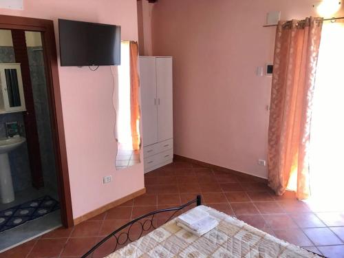 a room with a bed and a tv on the wall at B&B Teodora in Gaggi