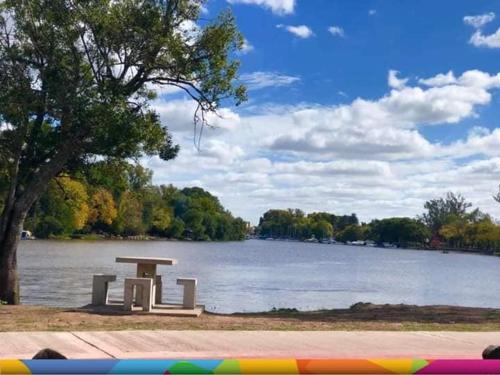 a park bench sitting next to a lake at Hotel Berlin in Gualeguaychú